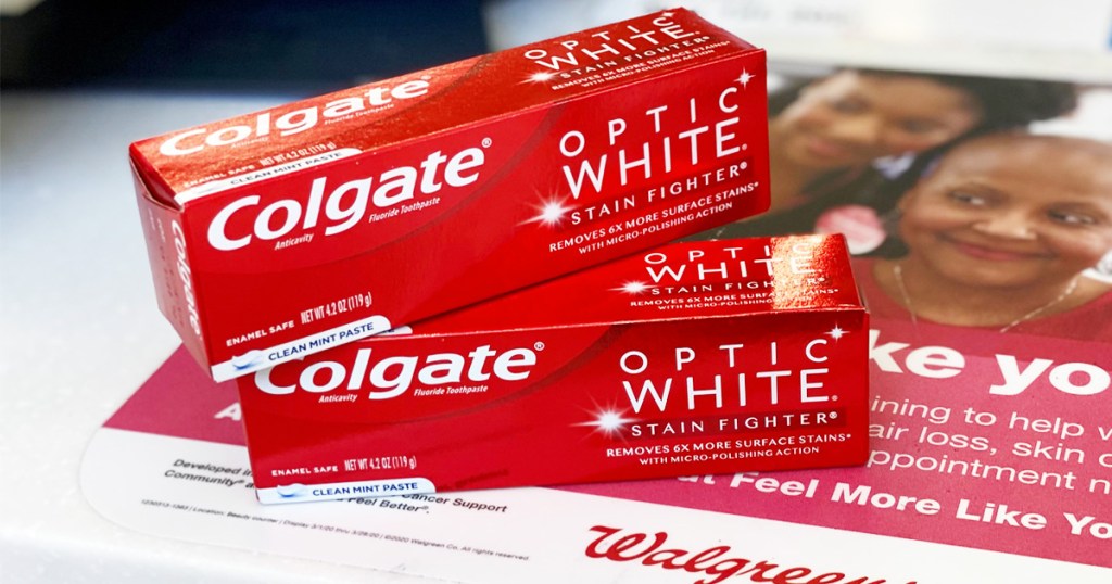 two red boxes of colgate optic white toothpaste stacked on one another on walgreens counter