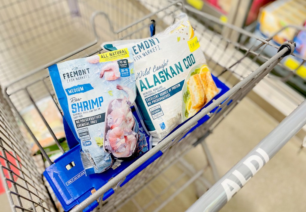 bags of frozen fish and shrimp in top of aldi store cart