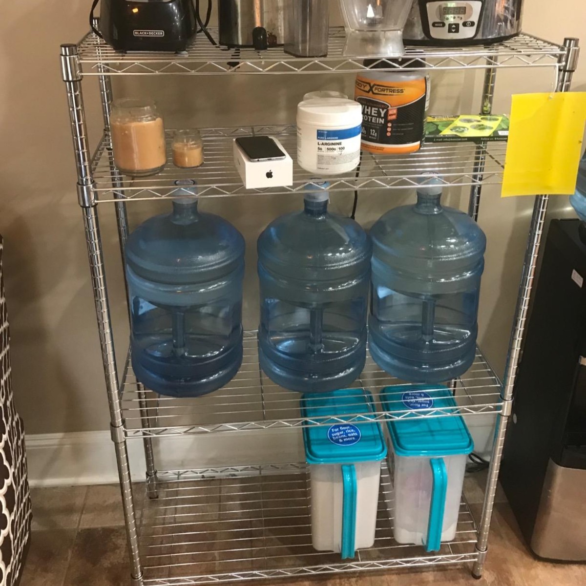 4-shelf storage unit holding large bottles of water