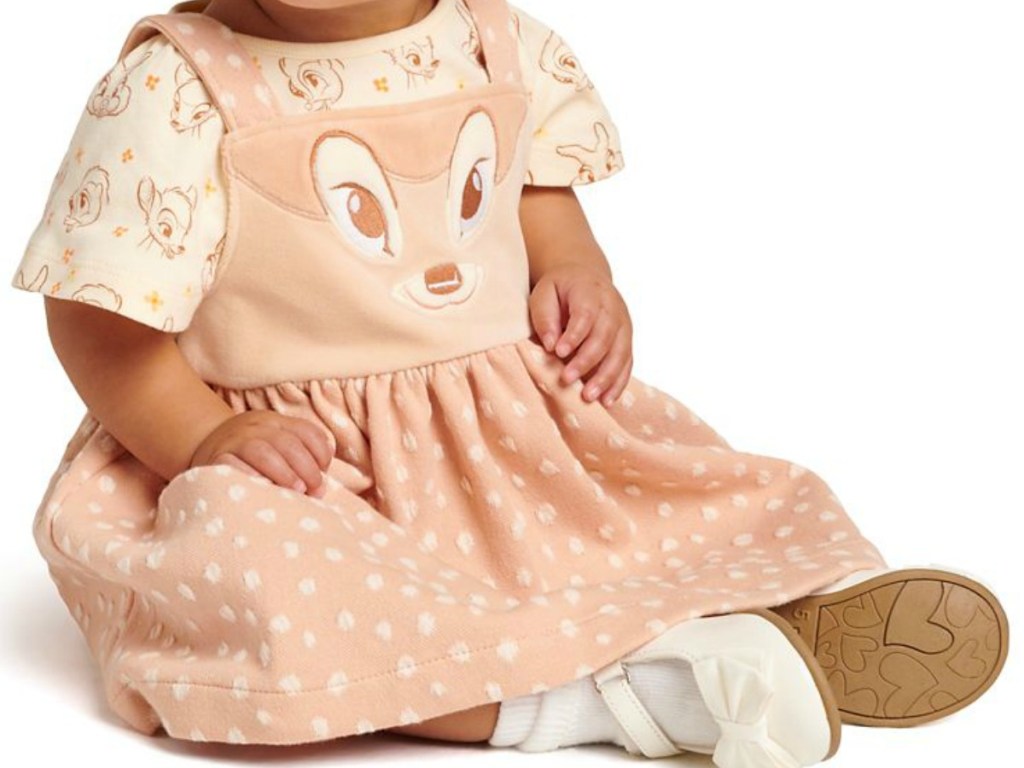 baby wearing dress with deer on it