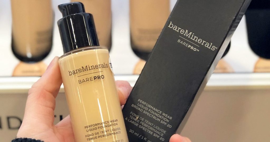 person holding up glass container of bareminerals foundation and packaging box