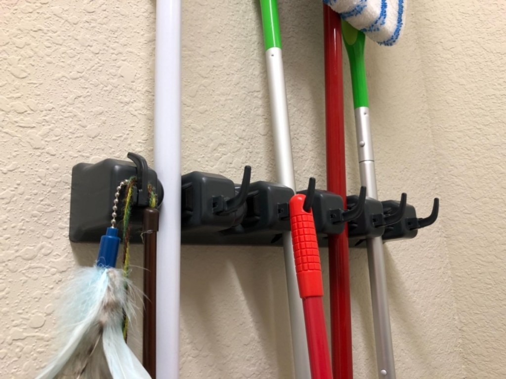 brooms and tools hanging from wall organizer