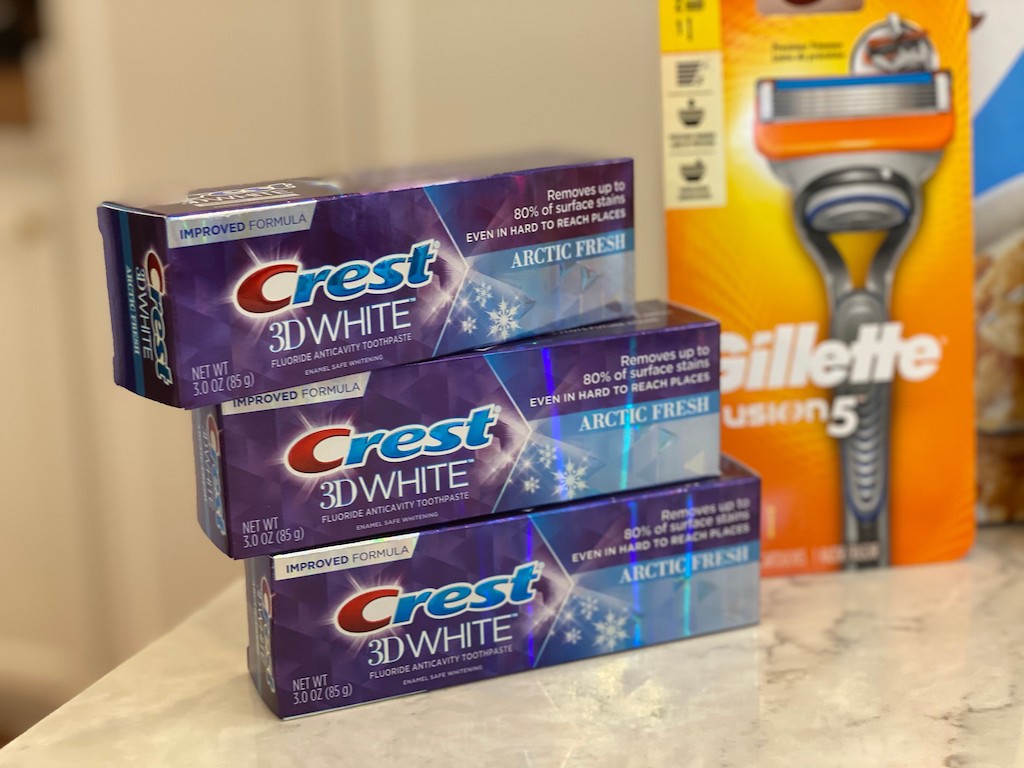 3 tubes of Crest toothpaste on counter next to Gillette razor
