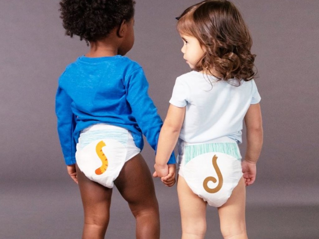 two toddlers holding hands wearing diapers and tees