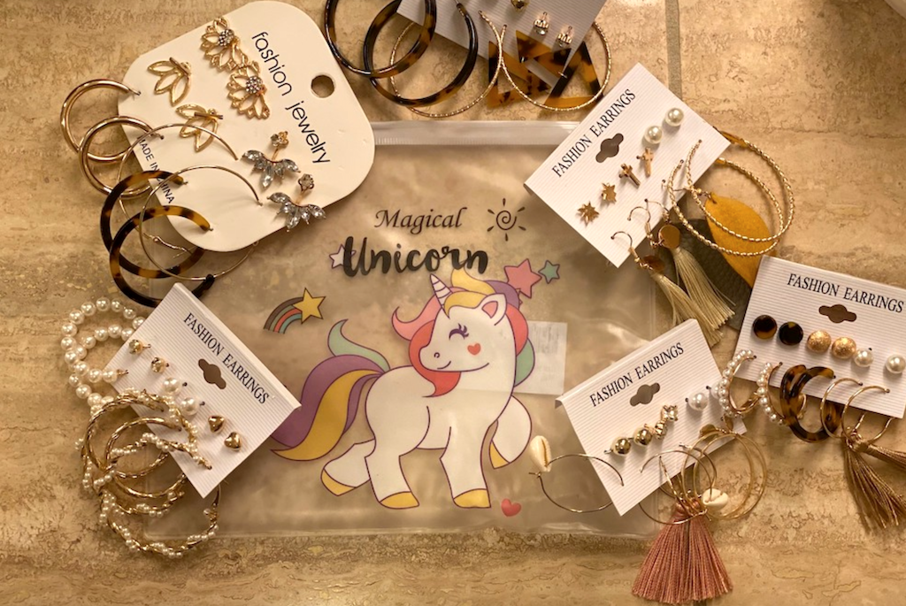 fashion earrings on counter with unicorn bag 