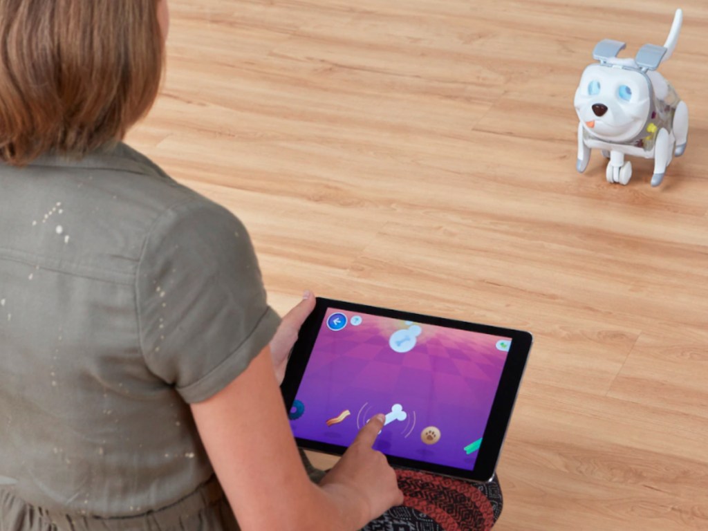 girl using ipad to play with robot dog