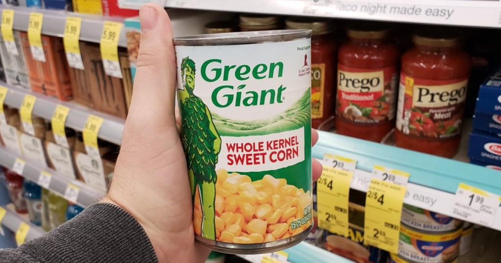hand holding can of corn in store