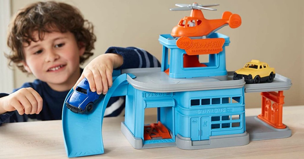 little boy playing with toy that looks like a parking garage