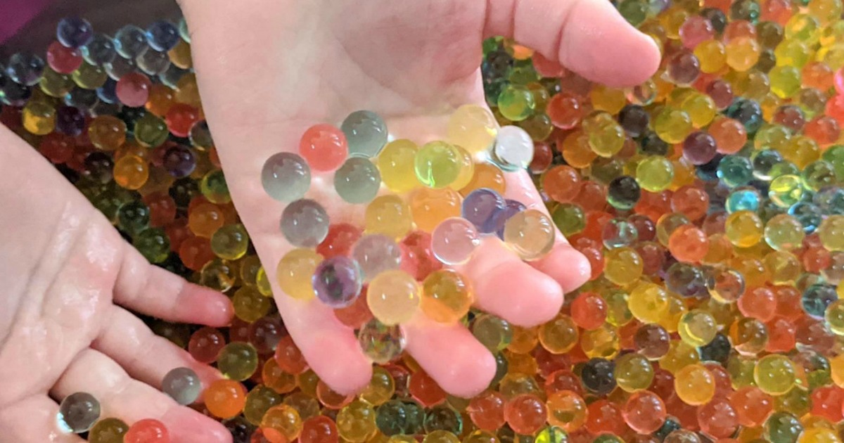 childs hands paying with water beads