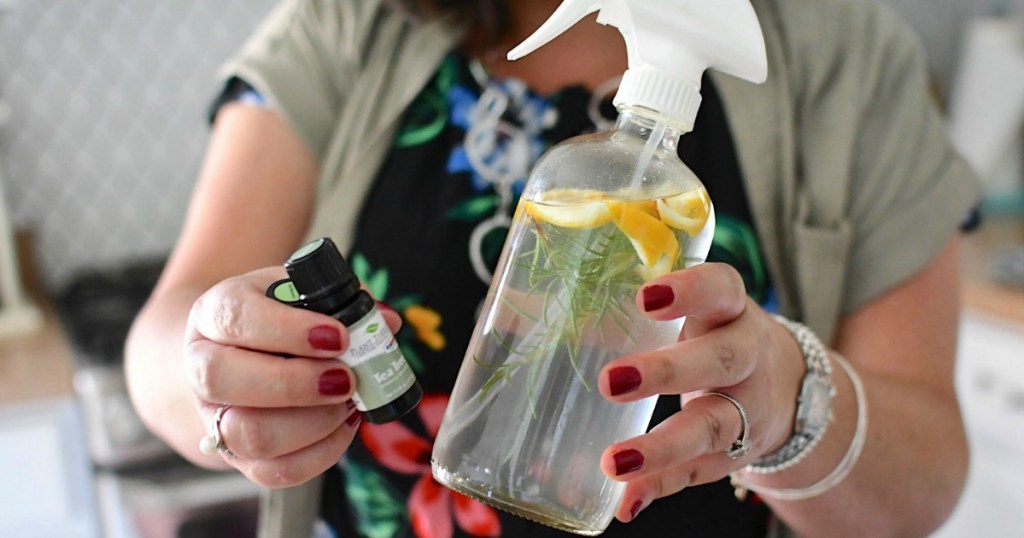 holding DIY cleaning spray with Plant Therapy essential oils 