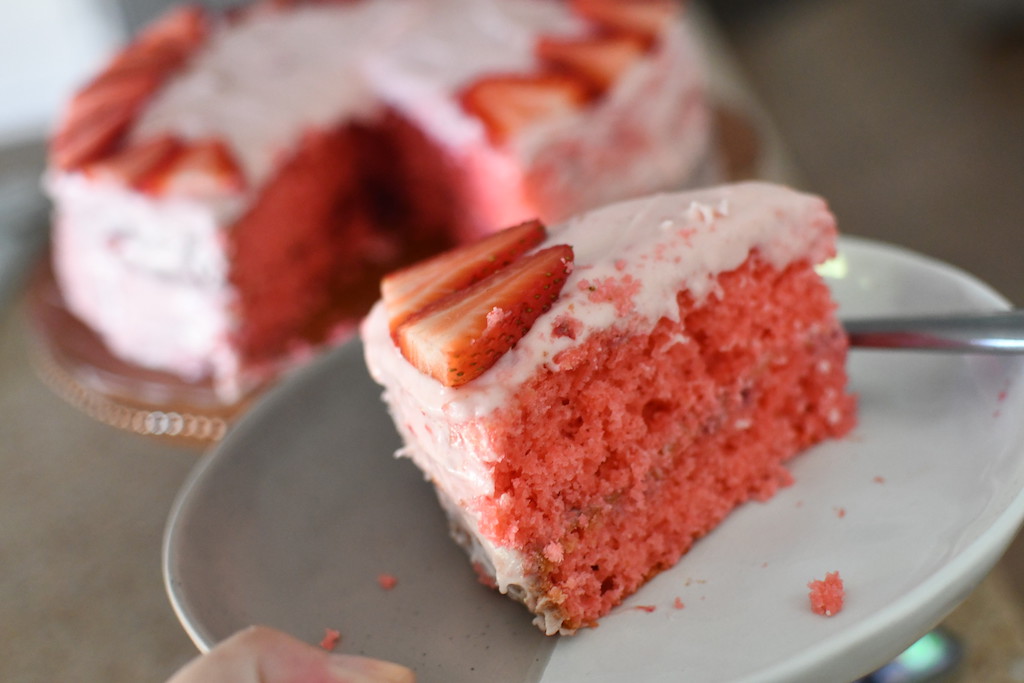 holding plate with strawberry cake slice on it 
