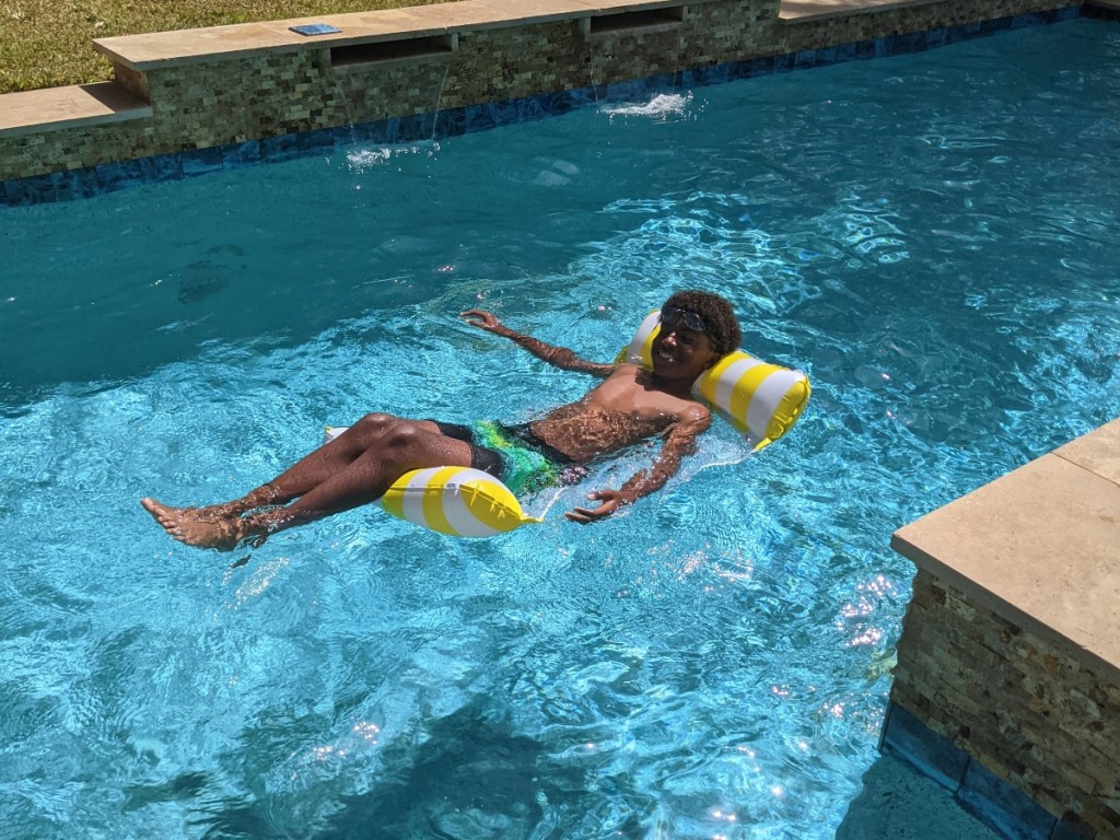 boy floating on pool hammock