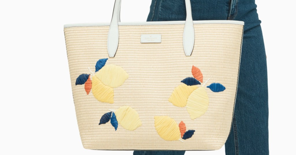 woman carrying straw kate spade tote with lemon theme
