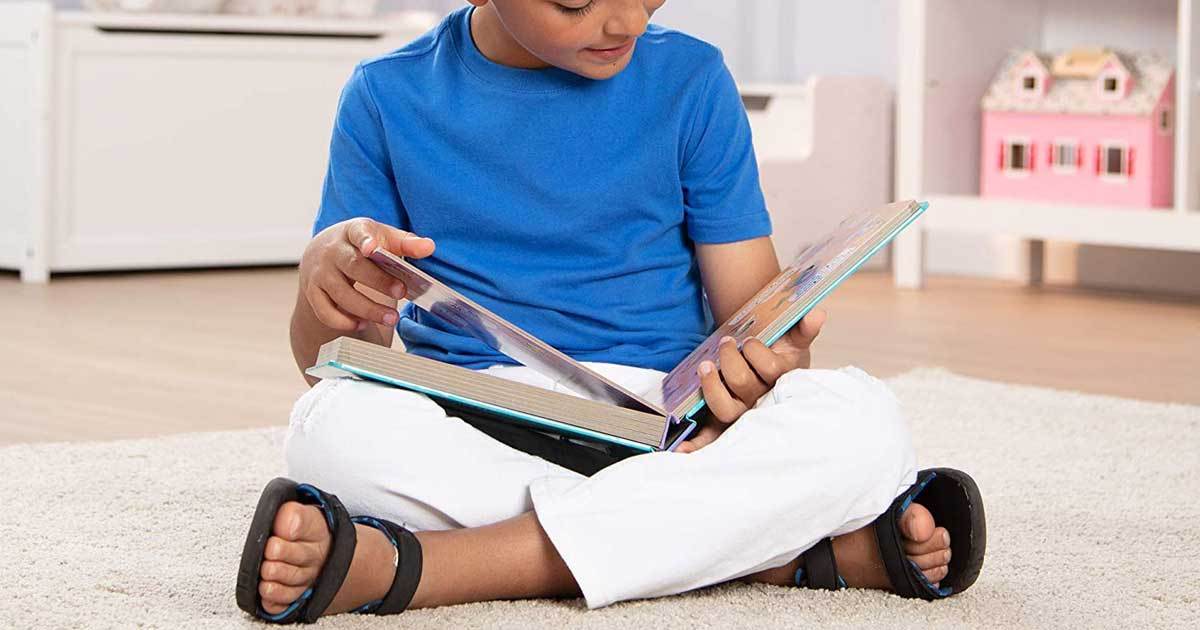 little boy holding a book and reading