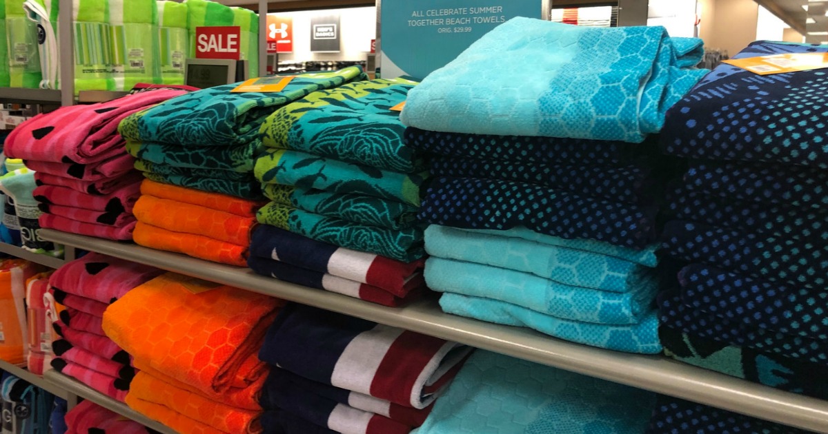 stacks of colorful beach towels on a store shelf