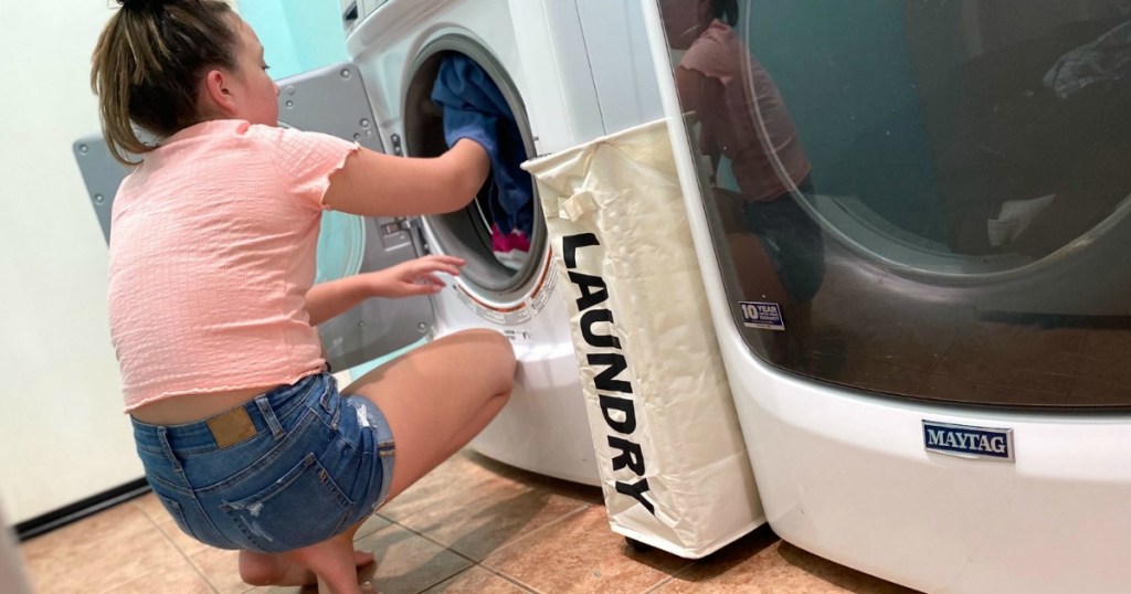 girl getting clothes out of front load dryer 
