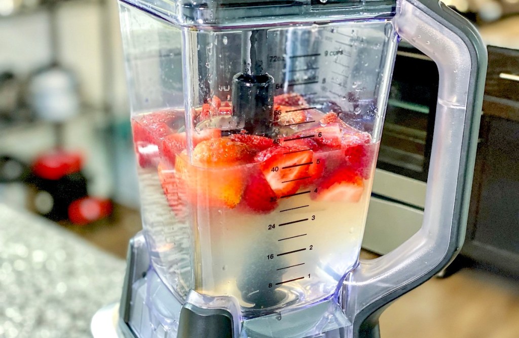 blender with strawberries and liquid inside