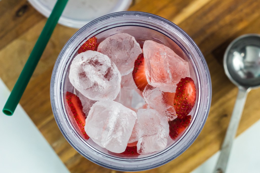 glass filled with ice and strawberry slices