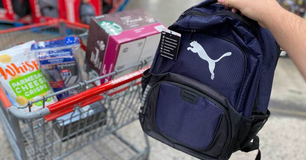 hand holding a puma backpack in a store