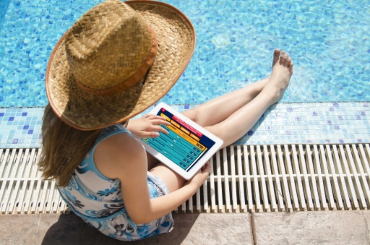 girl reading on tablet by pool
