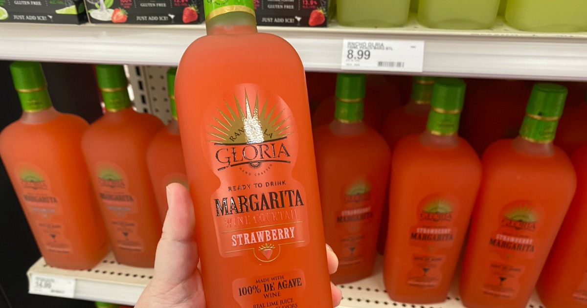 hand holding a bottle of ready to drink strawberry margaritas in front of store shelf