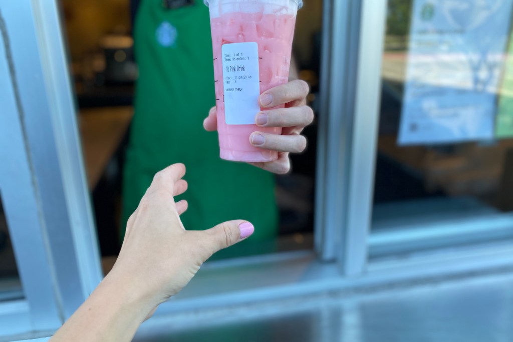 girl receiving Venti Pink Drink from Starbucks