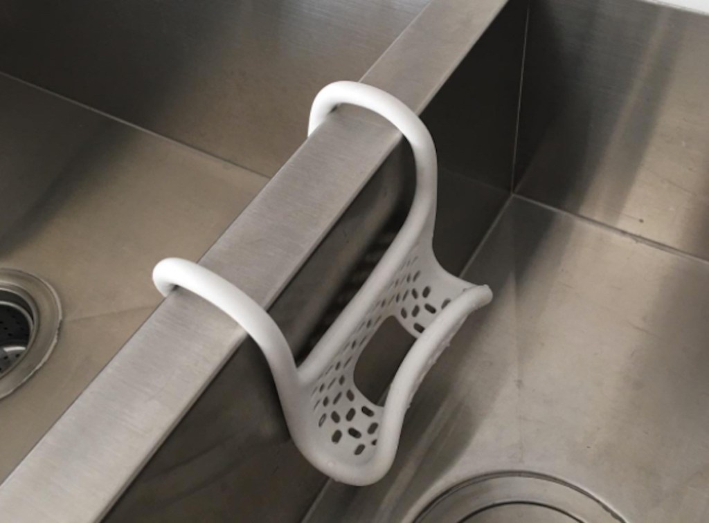 white sponge holder folded over stainless steel sink