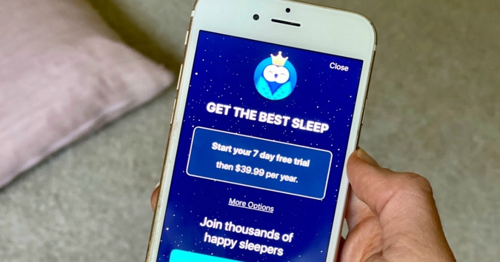 holding iphone with sleep app on screen 