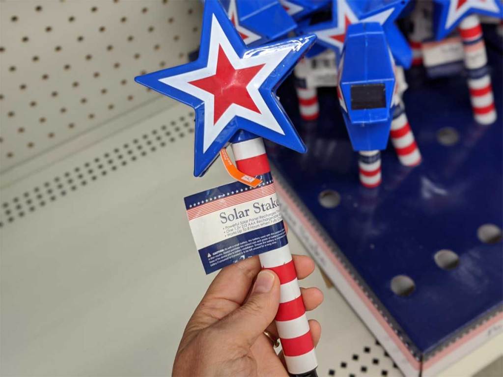 hand holding patriotic solar stakes
