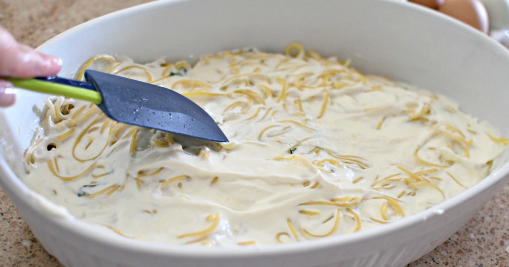 spreading cream cheese on noodles for million dollar spaghetti casserole