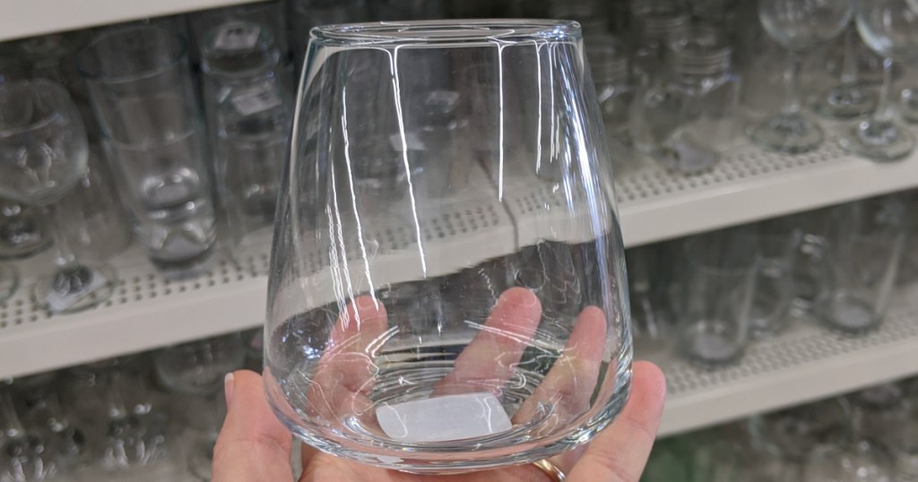 hand holding stemless wine glass in store