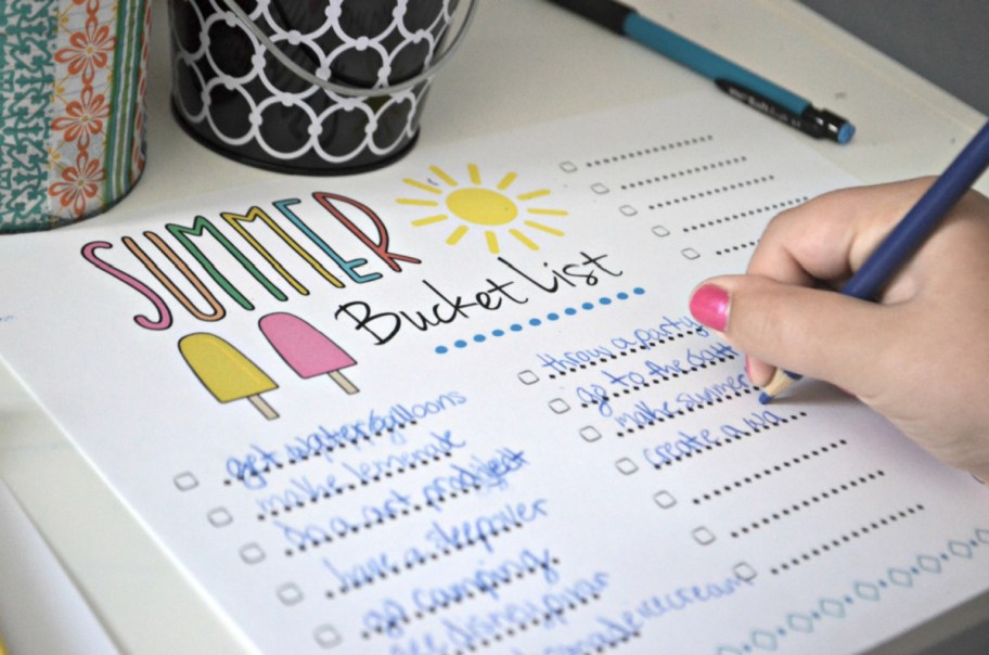 girl filling out a FREE summer bucket list
