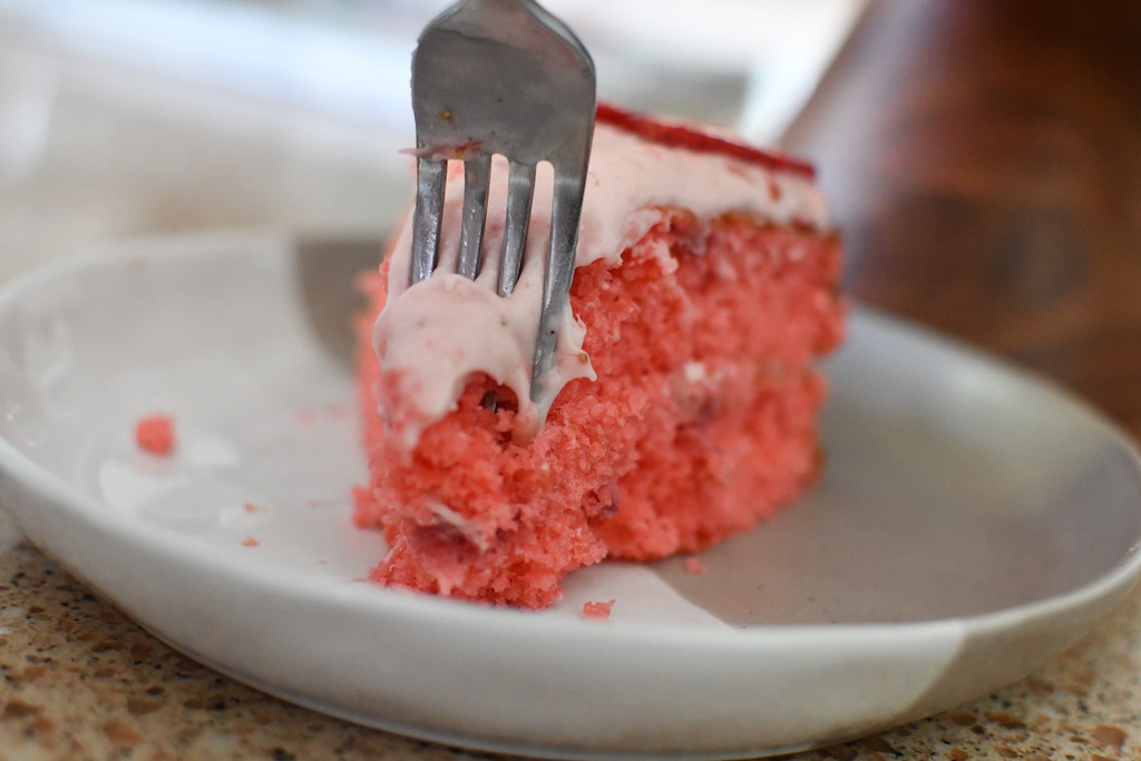 taking a bite with fork of strawberry cake 