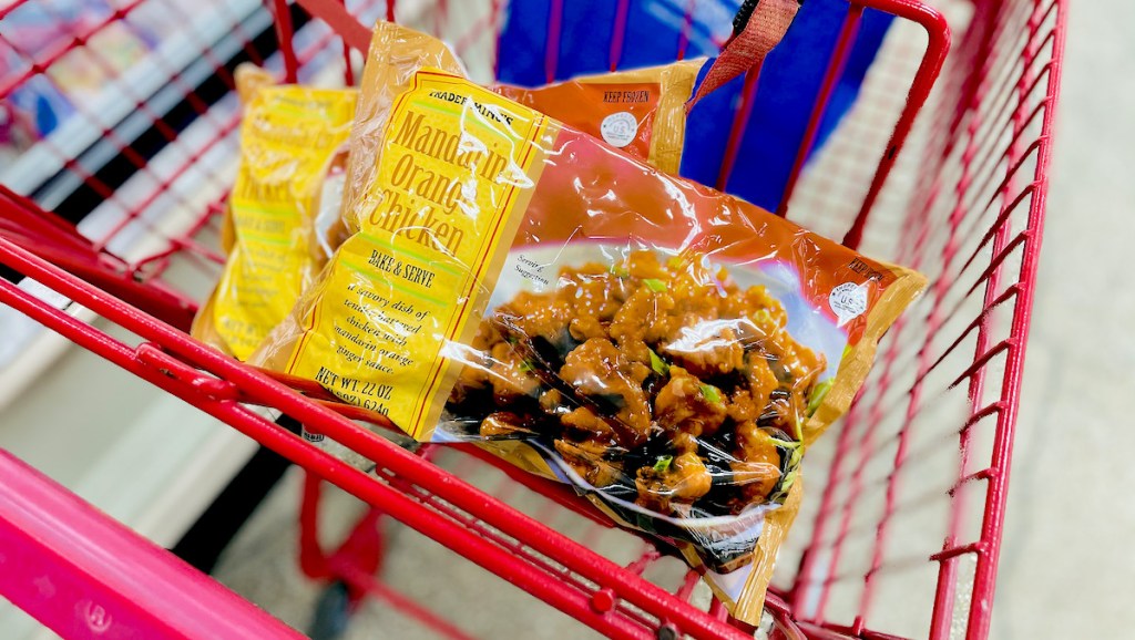 two bags of mandarin orange chicken sitting in top of red grocery cart- best Trader Joe's items