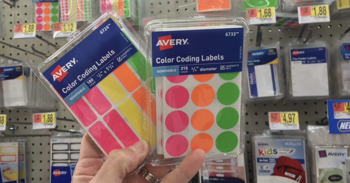woman hand holding up two boxes of avery color coding label packs inside of a walmart