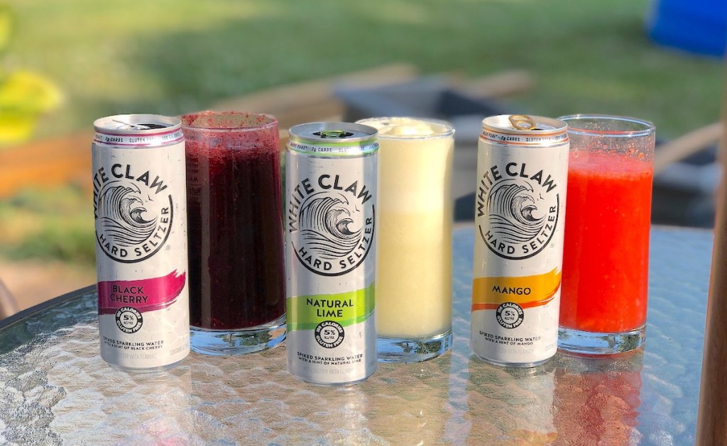 row of white claw cans and slushie drinks on outdoor glass tabletop