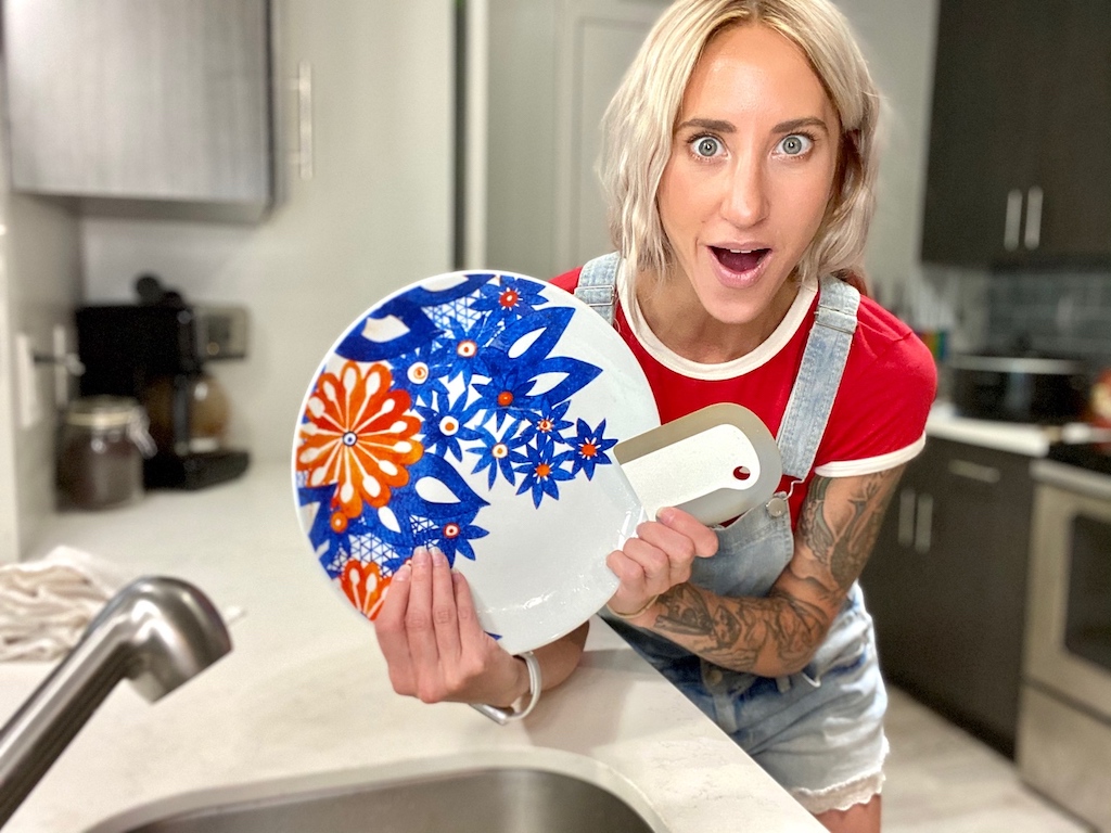 woman holding clean plate and dish squeegee