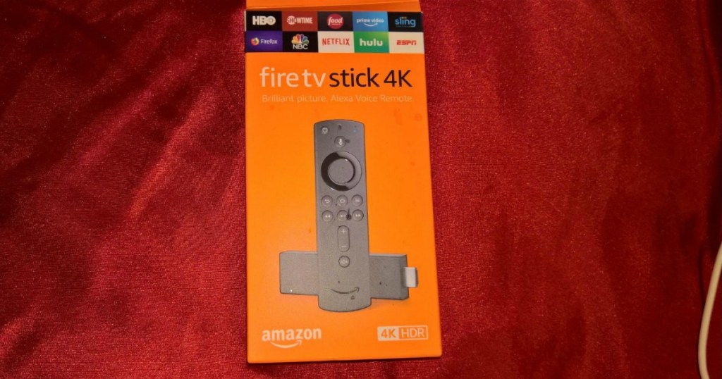 Smart TV remote in an orange package on a red fabric surface