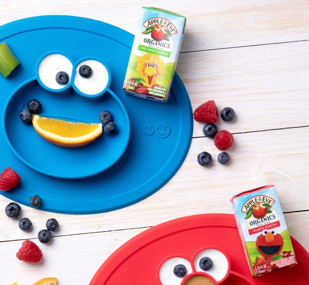 juice boxes on sesame street character shaped placemats with fruit around them