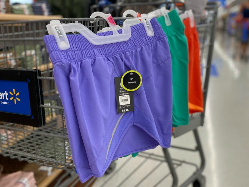 Three colors of women's athletic shorts hanging on a cart