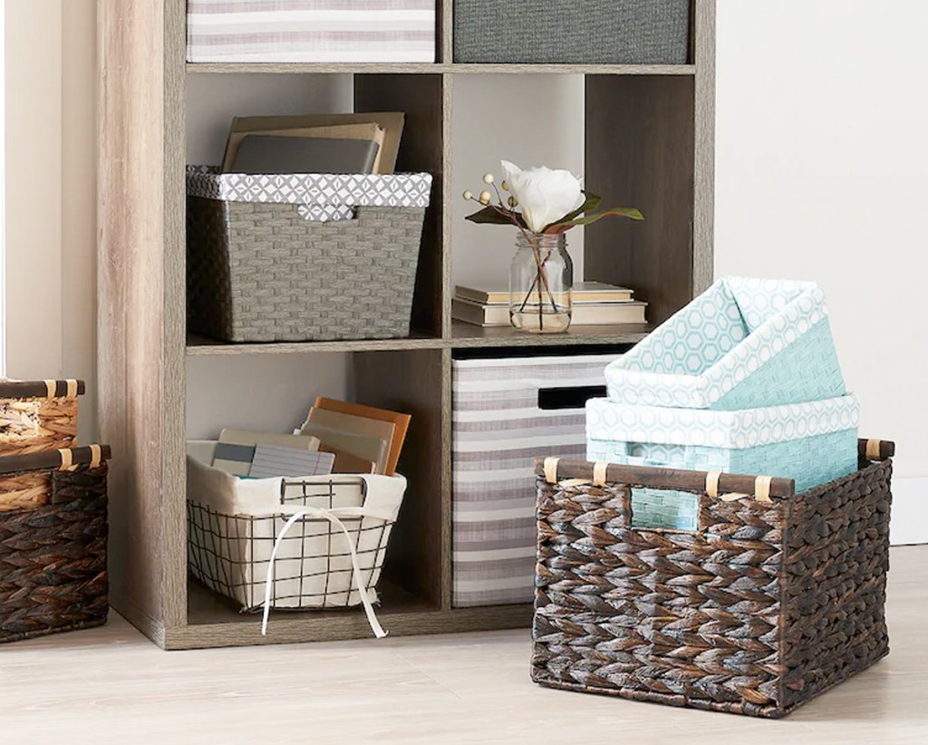 storage cubby with wire and fabric storage bins in each cubby and brown woven storage bin on floor