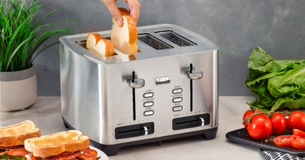 hand placing a slice of white bread into bella professional four slice toaster with another slice in a spot