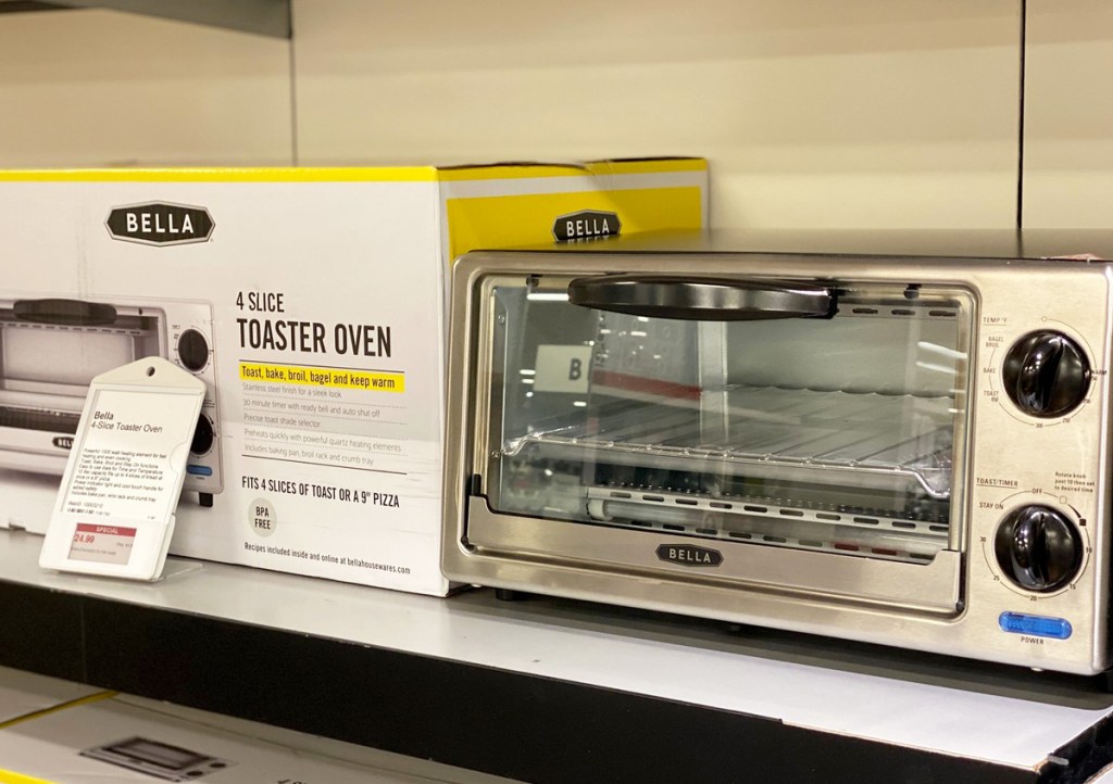 stainless steel toaster oven on display next to its yellow and white box on shelf