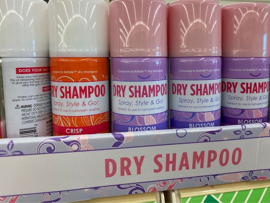 bottles of dry shampoo in cardboard tray on sore shelf 