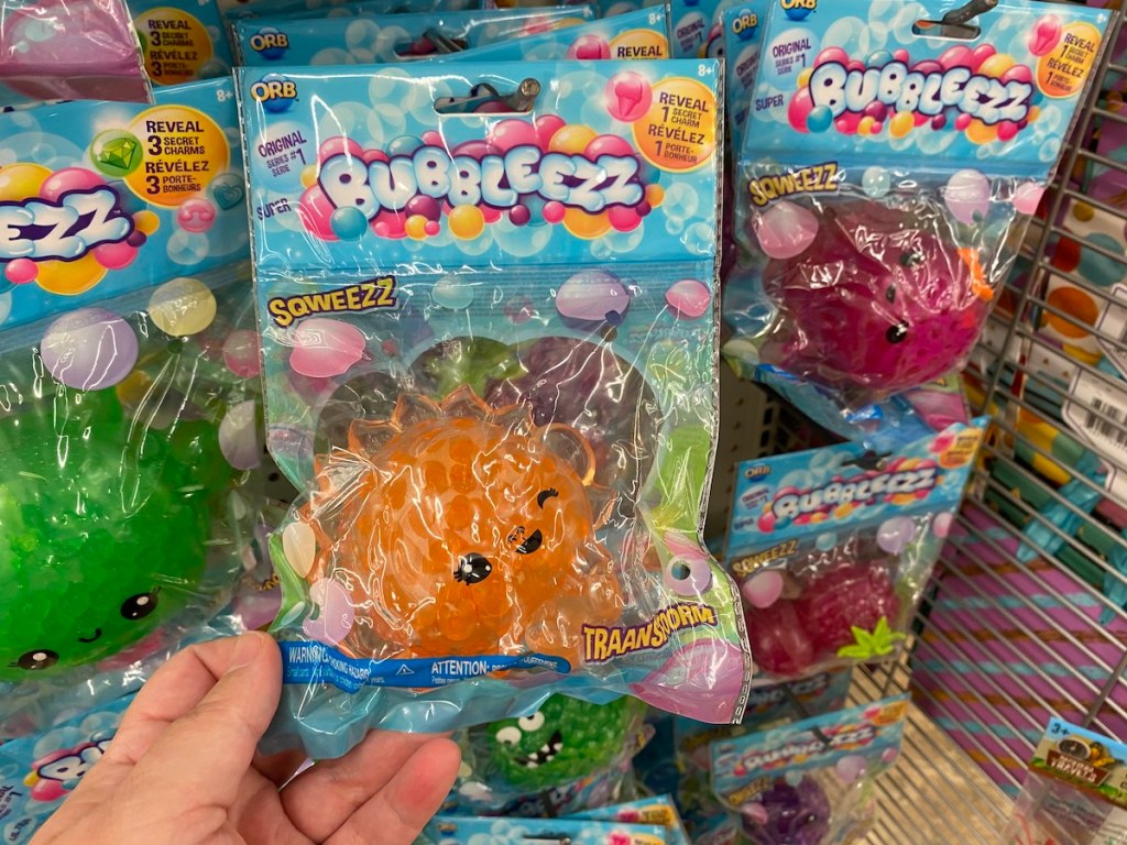 hand holding orange bubbleezz package with other colors behind it