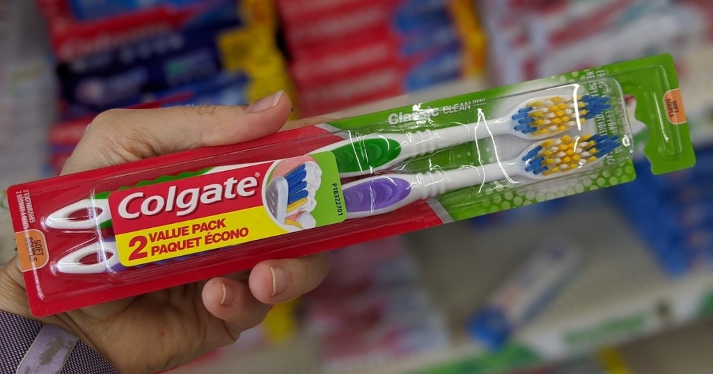 hand holding colgate toothbrush 2 pack