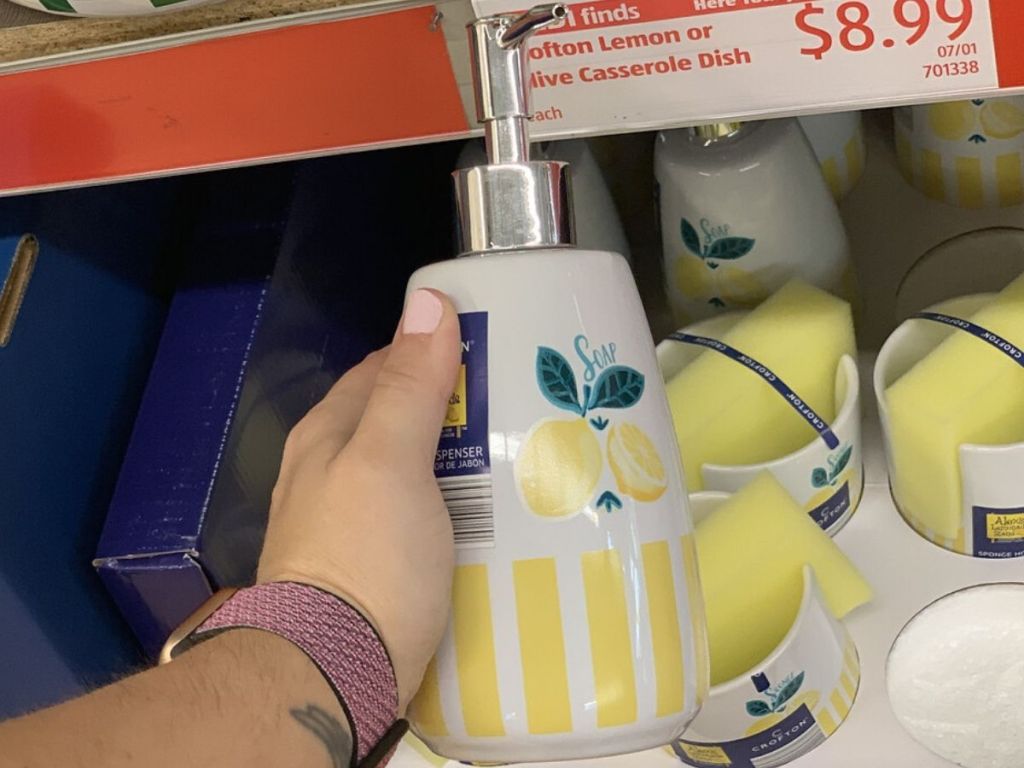 woman's hand holding a ceramic soap dispenser