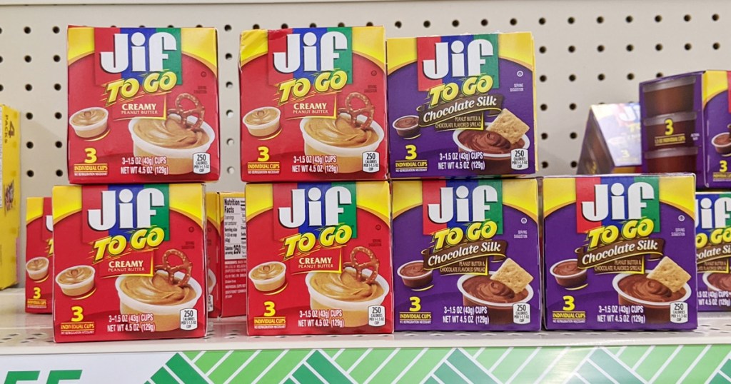 store shelf full of red and purple colored boxes of jif to-go peanut butter and chocolate silk cups