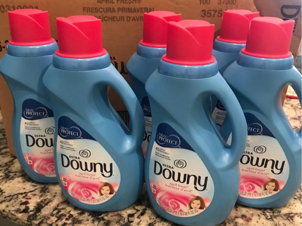 six bottles of fabric softener and shipping box on counter