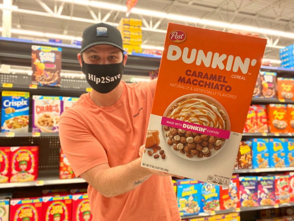 a man holding Dunkin cereal in a store